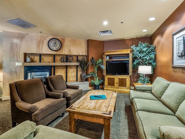 carpeted living room featuring a glass covered fireplace, recessed lighting, and visible vents