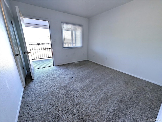 spare room featuring dark carpet