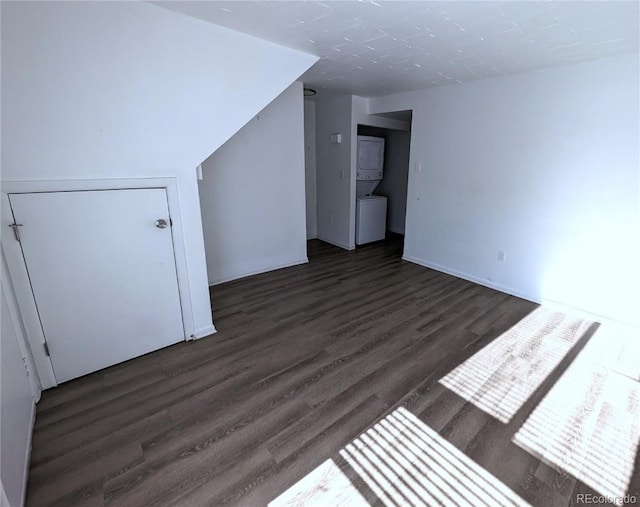 bonus room with stacked washer / dryer and dark wood-type flooring