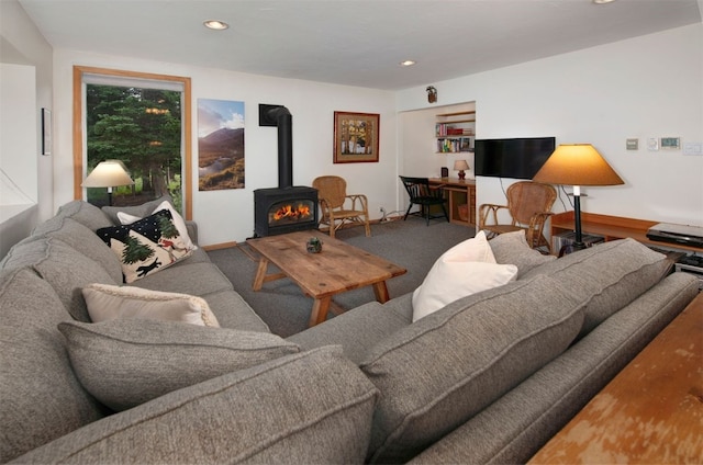 carpeted living room with a wood stove