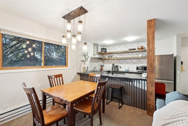 dining room featuring carpet flooring, baseboard heating, and sink