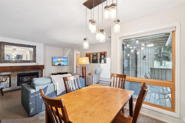 carpeted dining space with a tile fireplace