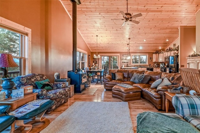 living room featuring high vaulted ceiling, a wood stove, wooden ceiling, and light hardwood / wood-style floors