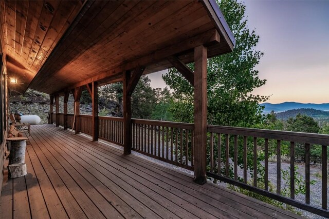 deck at dusk featuring a mountain view