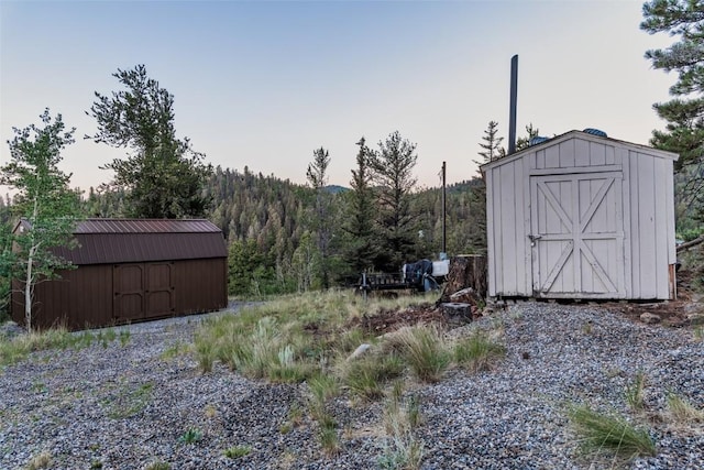 yard at dusk featuring a storage shed