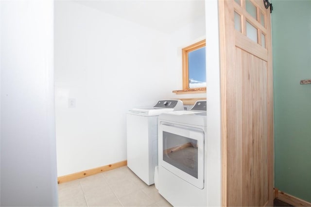 clothes washing area featuring washer and clothes dryer and light tile patterned flooring