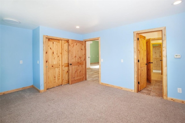 unfurnished bedroom with light carpet and a closet