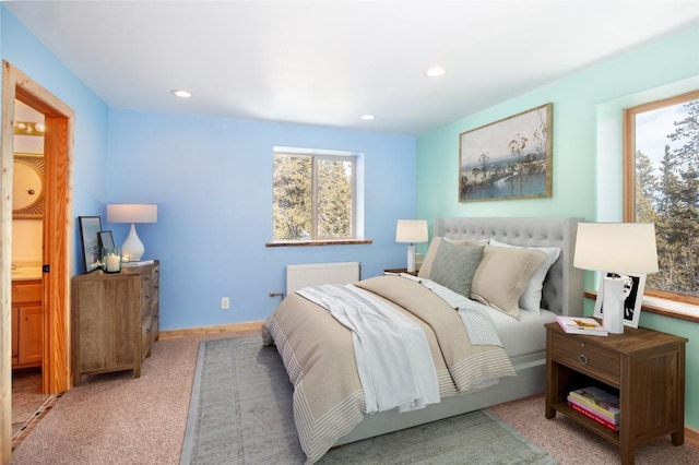 bedroom featuring light colored carpet and radiator