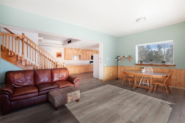 living room with hardwood / wood-style flooring and wooden walls