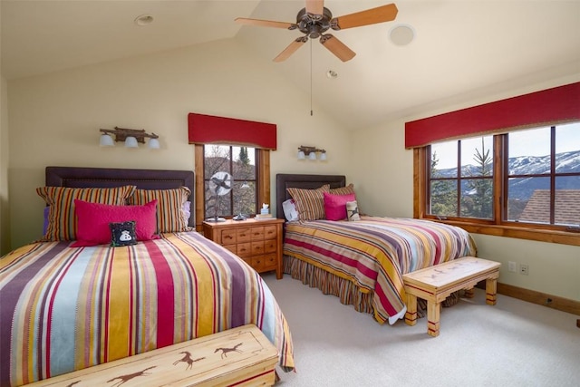 carpeted bedroom with a mountain view, vaulted ceiling, multiple windows, and ceiling fan