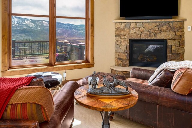 living room featuring carpet flooring and a stone fireplace