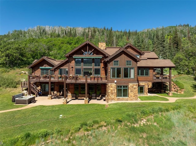 rear view of property featuring a patio area, an outdoor living space, a yard, and a wooden deck