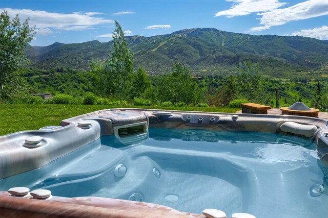 view of pool featuring a mountain view and a hot tub