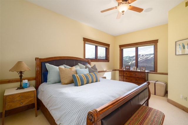 carpeted bedroom featuring a mountain view and ceiling fan