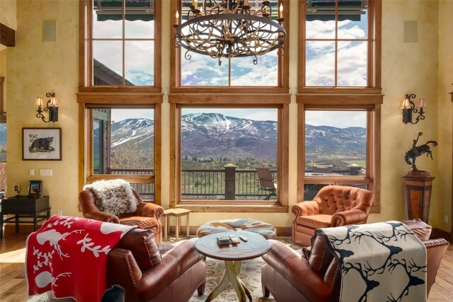 interior space featuring a mountain view, hardwood / wood-style floors, a high ceiling, and an inviting chandelier