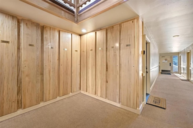 interior space with light colored carpet and wooden walls