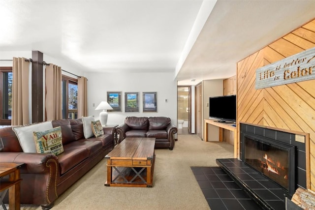 living room with a fireplace and dark carpet