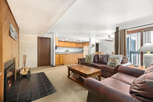 carpeted living room featuring wood walls