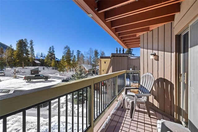 view of snow covered back of property