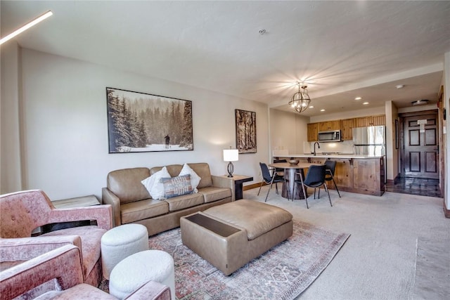 carpeted living room featuring sink and a notable chandelier