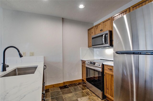 kitchen with sink, decorative backsplash, and appliances with stainless steel finishes