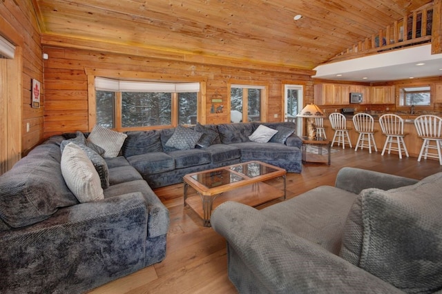 living room featuring wood ceiling, plenty of natural light, light hardwood / wood-style floors, and wood walls