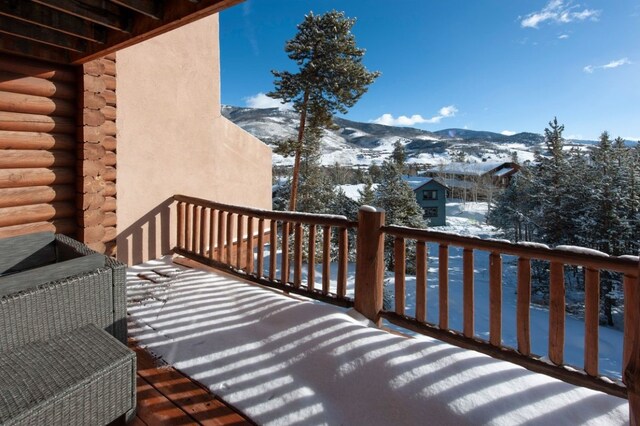 snow covered back of property with a mountain view