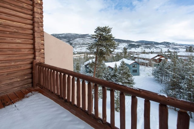 snow covered back of property with a mountain view