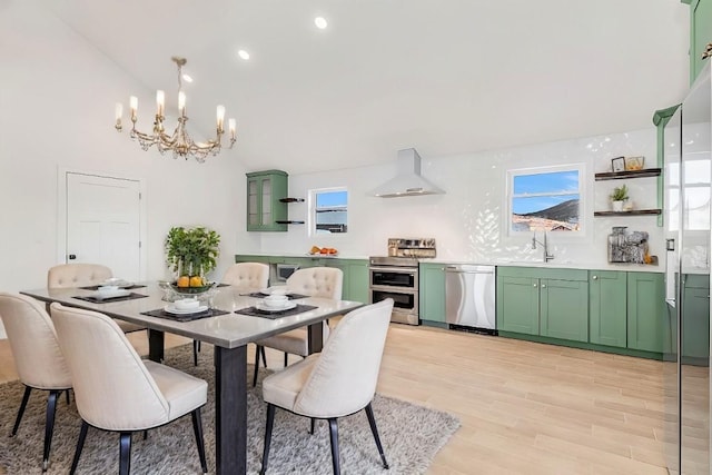 dining space featuring a notable chandelier, light wood-type flooring, sink, and vaulted ceiling