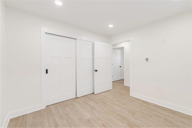 unfurnished bedroom featuring a closet and light hardwood / wood-style flooring