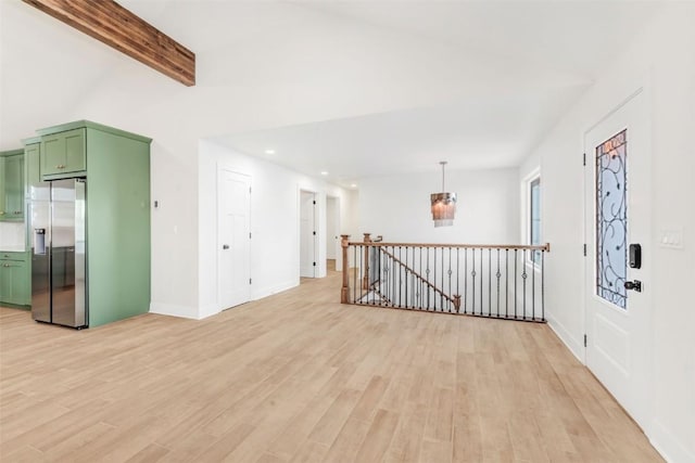 unfurnished room featuring beam ceiling and light hardwood / wood-style floors