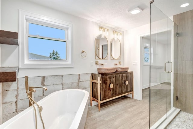 bathroom with vanity, shower with separate bathtub, a textured ceiling, and hardwood / wood-style floors