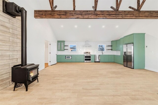 living room with a wood stove, beamed ceiling, light hardwood / wood-style floors, and high vaulted ceiling