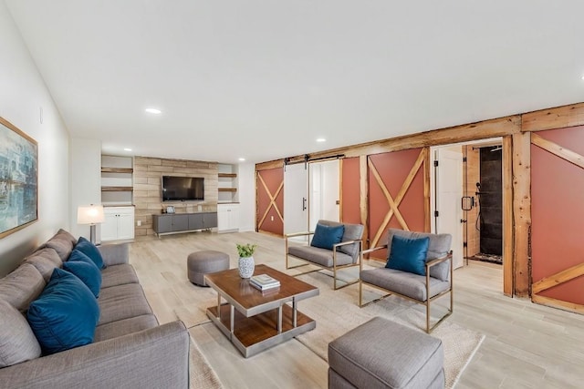 living room featuring a barn door and light hardwood / wood-style floors