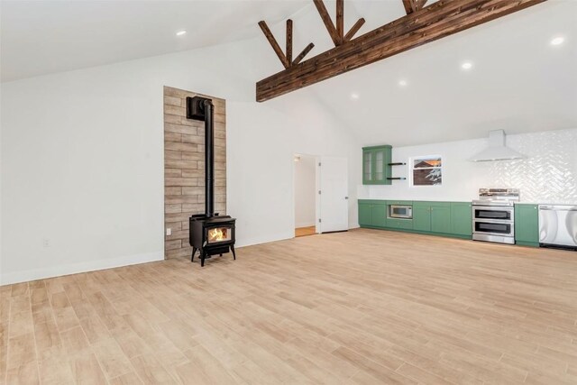 unfurnished living room featuring a wood stove, beamed ceiling, high vaulted ceiling, and light wood-type flooring