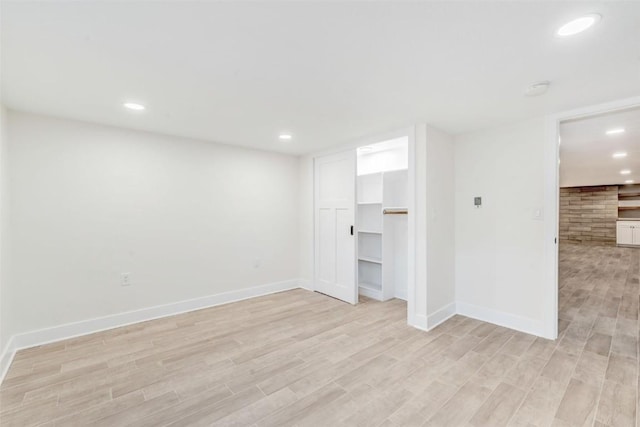 interior space with a spacious closet, a closet, and light hardwood / wood-style floors