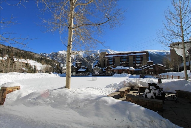 yard layered in snow featuring a mountain view