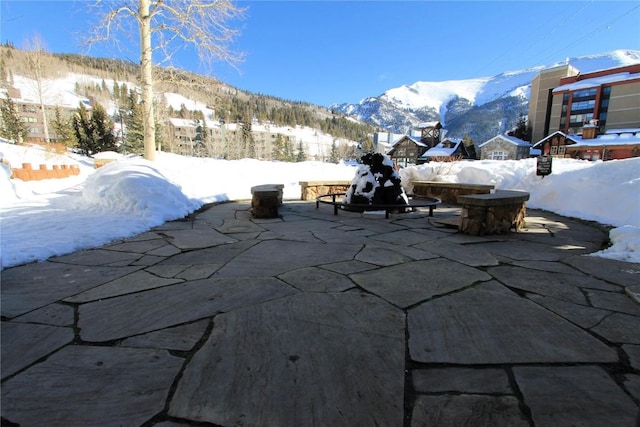 snow covered patio with a mountain view