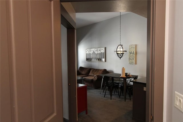 dining area featuring dark colored carpet and lofted ceiling