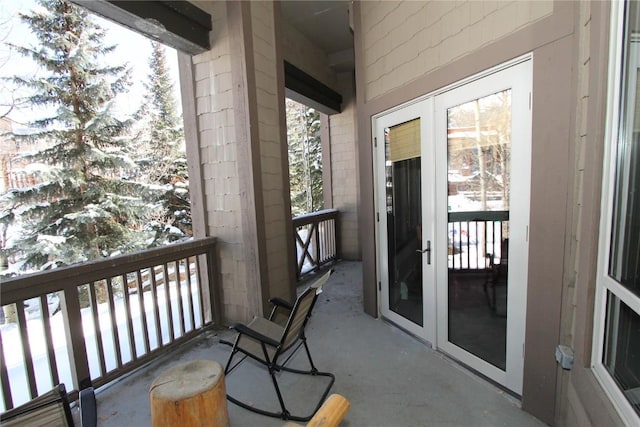 snow covered back of property featuring french doors