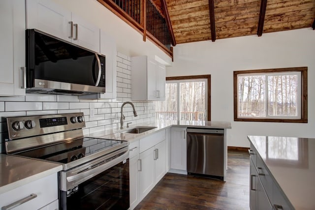 kitchen with stainless steel appliances, backsplash, dark wood-type flooring, a sink, and wooden ceiling