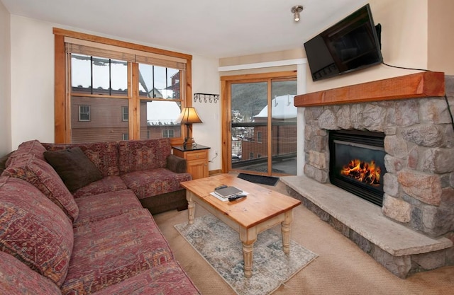 living room featuring a stone fireplace and plenty of natural light