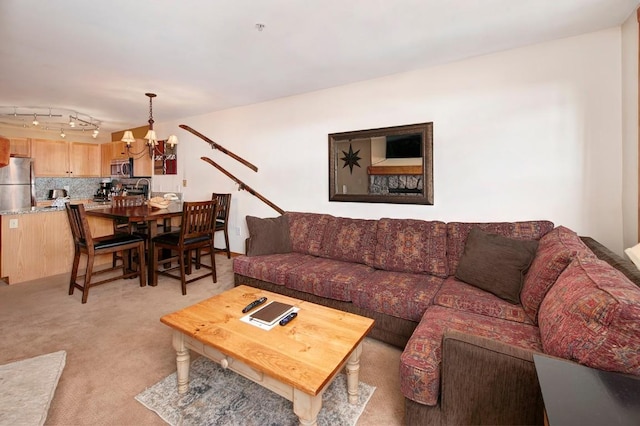 living area with light carpet and a chandelier