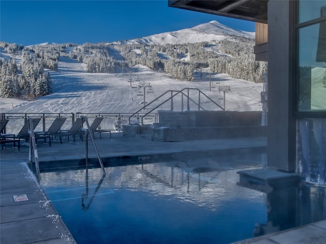 snow covered pool featuring a mountain view