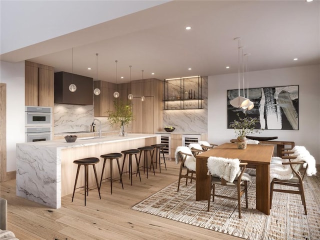 dining room featuring light wood-style floors, recessed lighting, and wine cooler