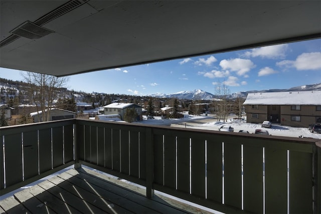 snow covered back of property featuring a mountain view