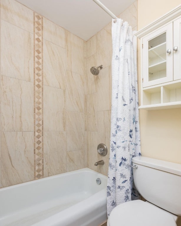 bathroom with shower / bath combo with shower curtain and toilet