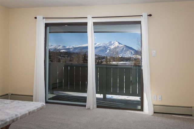 doorway to outside with carpet flooring, a baseboard radiator, and a mountain view