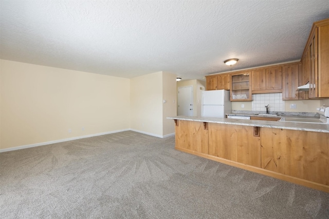 kitchen with white refrigerator, carpet, a kitchen bar, kitchen peninsula, and range