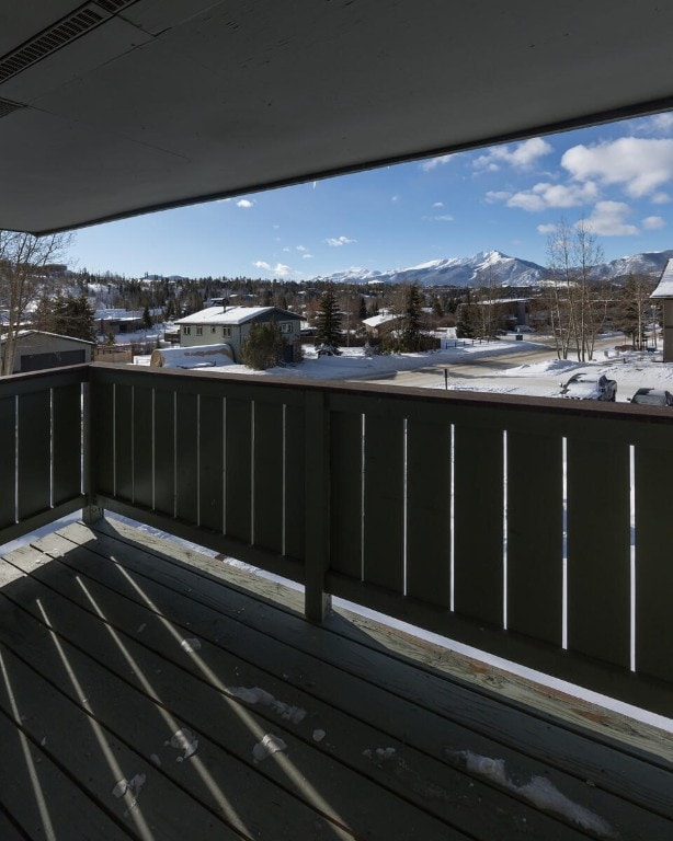 snow covered back of property with a mountain view